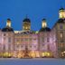 Althoff Grandhotel Schloss Bensberg in Bergisch Gladbach, illuminated palace facade with snowy courtyard at dusk