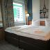 Hotel Near By in Laatzen: double bed with Eiffel Tower wall art and window view in a guest room