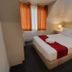 The Shakespeare Hotel Auckland guest room with double bed, red runner, bedside lamp and window