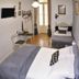 Alvares Cabral Guest House in Porto, twin room with two single beds, wall-mounted TV, and small table by balcony doors.