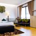 Panlaan Boutique Resort in Nong Khai guest room with king bed, seating nook, lamps and wall art