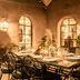 Le Jardin Des Douars in Essaouira: warm courtyard dining area with arched windows and wrought-iron chairs