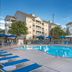 Club Wyndham Nashville pool area with blue loungers and umbrellas beside condo-style buildings