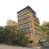 Motoyu No Yado Kurodaya in Beppu, a multi-story hotel building surrounded by trees and a driveway