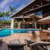 Ilha Flat Hotel in Ilhabela with a tropical outdoor pool, palm trees, and sun loungers by the deck.