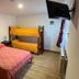 Hosteria Ailen in Ushuaia guest room with double bed, bunk bed, wall TV and window