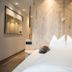 Hotel Bad Fallenbach guest room with double bed, wood wall feature, and modern minimalist decor in San Leonardo in Passiria