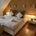 Berghotel Drei Brüder Höhe in Marienberg: cozy attic hotel room with double bed and bedside lamps