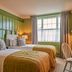 The White Horse, Dorking guest room with twin beds, green walls, and a window with curtains