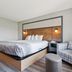 AmericInn by Wyndham Wisconsin Dells guest room with king bed and plaid armchair
