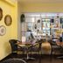 Canal Aigues Mortes lounge dining area with tables, chairs, shelving and ocean mural in Aigues-Mortes