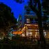 Karystion Hotel in Kárystos, illuminated at night behind trees with a glass-fronted terrace.