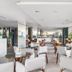 Citi Hotel Express Caruaru lounge with white chairs, glass tables, and large windows in Caruaru