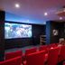 Domaine De La Corniche in Rolleboise, private hotel cinema with red seats and wall art