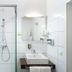 Hotel-Residenz Immenhof bathroom in Sankt Martin with glass shower, sink and mirror