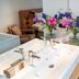 Bij Jef Den Hoorn bathroom vanity with flowers and bedside seating beside a bedroom