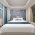 Hong Yun Dong Du Hotel in Qingdao guest room with double bed, floral accent wall and large window