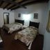 Mar de Cortez in Cabo San Lucas: simple twin bedroom with two beds, wood-beam ceiling, and tiled floor