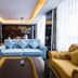 Parkyard Hotel Jiaxing in Jiaxing: stylish suite seating area with blue sofa, yellow armchairs and city-view windows