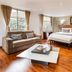 Hotel Porton De La Cabrera in Bogotá with king bed, sofa, coffee table and wood floors in a bright suite