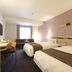Karasuma Kyoto Hotel room in Kyoto with two twin beds, desk, sofa and window light