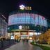 Ruizhao Hotel (Beijing Guomao Branch) in Beijing at night, with a lit curved glass facade and walkway