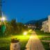 Kyparissia Blue Boutique Hotel in Kyparissía: lit garden path beside white hotel building at dusk