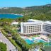 Ozkaymak Marina Hotel in Kemer with sea view, palm trees, and outdoor pool by the coast
