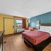 Econo Lodge Charlotte Airport Area guest room with king bed, teal accent wall and seating area in Charlotte