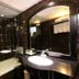 Hanoi Crystal Hotel bathroom with bathtub, black tiled walls, and large mirror in Hanoi