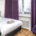 Hotell Linden in Östersund room with single bed, purple curtains, window view and folded towels
