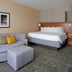 Courtyard by Marriott Aberdeen at Ripken Stadium guest room with bed, sofa, ottoman and floor lamp