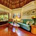Riviera Maya Suites in Playa del Carmen, thatched-roof suite with teal sofa and tropical patio view