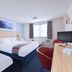 Travelodge Manchester Birch M62 Eastbound room with two beds, desk, TV and window in Heywood
