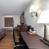 Red Roof Inn Warrenton room with king bed, desk, TV, chair and window with curtains in Warrenton.