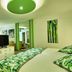 Hotel Riu Tequila in Playa del Carmen, green-themed guest room with bed, sofa, TV, and balcony view