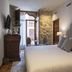 Hotel Cetina Palacio de los Salcedo room in Baeza with king bed, stone wall and balcony doors