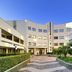 Park Hotel Mirabeau in Gasperina courtyard with landscaped paths and modern curved hotel facade