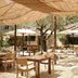 Le Moulin, Lourmarin outdoor terrace with wooden tables, umbrellas and shaded garden seating