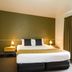 Tall Timbers Tasmania in Smithton: modern hotel room with king bed, bedside lamps, and heavy curtains