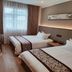 Yangjianhua Hotel (Shanghai Hu'nan) guest room with two beds, desk, and large window in Shanghai
