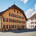 Hôtel de l'Aigle in Val-de-Travers, a traditional alpine-style hotel with red shutters and a sloped roof