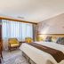 Guoyi Hotel Beijing guest room with king bed, desk, chairs, and large window with curtains