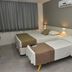 Hotel Três Caravelas room in Fortaleza with two single beds, wall-mounted AC and gray walls