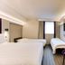 Purple Roomz Preston South (Cuerden Way) in Preston guest room with two beds and a wall-mounted TV