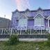 Hosteria Ailen in Ushuaia, purple guesthouse with white trim and fenced front yard