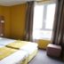 Hôtel de France in Boulogne-Billancourt, twin bed hotel room with window and mustard walls