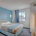Econo Lodge Menomonie guest room with a bed, blue accent wall, and window view in Menomonie