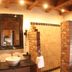 Hazienda Apartmenthotel in Gernsbach bathroom with vessel sink, brick shower, and wood-beamed ceiling