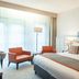 Parkhotel Tjaarda Oranjewoud guest room with king bed, orange chairs and large bright windows